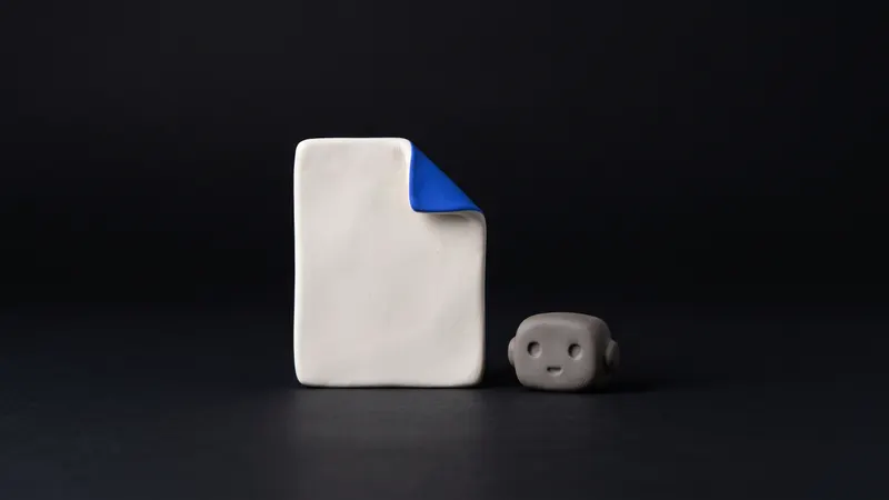 A matte clay sheet of paper folded at one corner with a small cobalt tab, on a near-black background